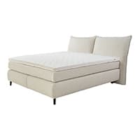 Helles Boxspringbett mit hohem Kopfteil und breiter Liegefläche.