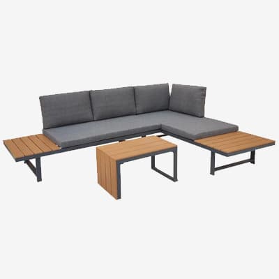 Ecksofa mit grauen Polstern, seitlichen Ablageflächen und zwei passenden Beistelltischen davor