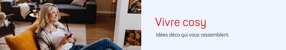Vivre cosy – Idées déco qui vous ressemblent, personne assise détendue dans un salon avec tasse à la main
