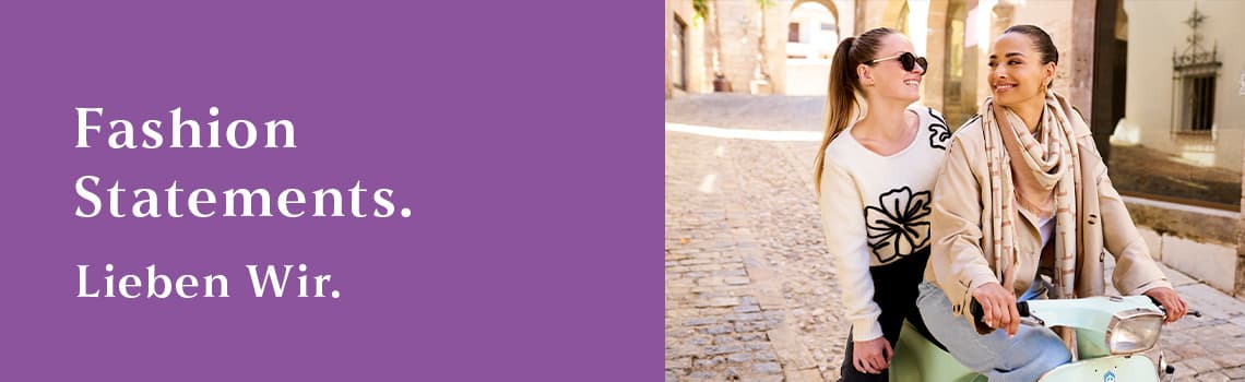 Fashion Statements. Lieben Wir. – Zwei Personen in modischer Kleidung sitzen auf einem Motorroller auf einer gepflasterten Strasse