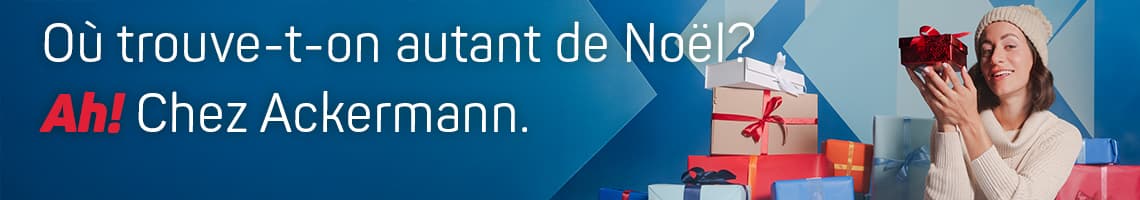 Où trouve-t-on autant de Noël? Ah! Chez Ackermann. Personne tenant un cadeau rouge, entourée de nombreux autres cadeaux emballés.