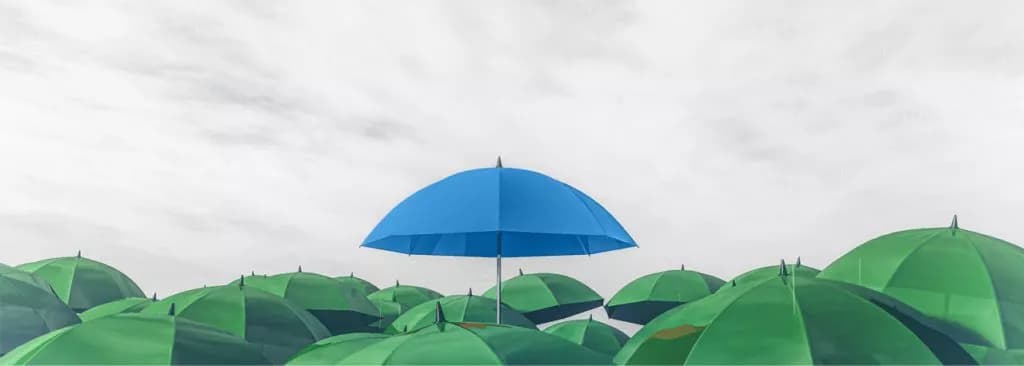 Un parapluie bleu dans une mer de parapluies verts.