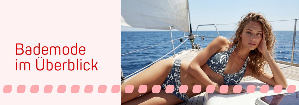 Bademode im Überblick – Frau im gemusterten Bikini liegt entspannt auf einem Segelboot vor blauem Meer
