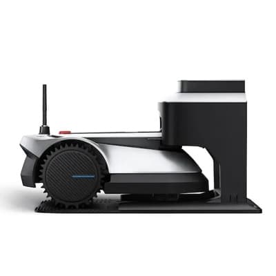 Mähroboter seitlich in seiner Ladestation, mit sichtbarem Antriebsrad und Antenne nach oben