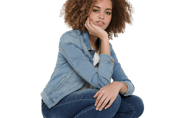 Verschiedene bunte Kissen auf einem beigefarbenen Sofa, im Hintergrund ein abstraktes Gemälde.