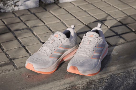 BISSELL logo – Person using BISSELL carpet cleaner to remove dirt from beige carpet