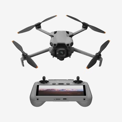 Drone gris avec caméra et télécommande affichant un paysage sur son écran.