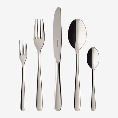 Besteckset mit Gabel, Messer, Löffel, Kuchengabel und Teelöffel nebeneinander auf hellem Hintergrund