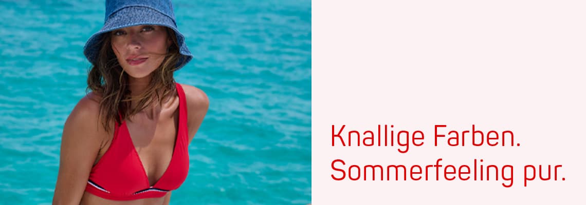 Knallige Farben. Sommerfeeling pur. Frau im roten Bikinioberteil am türkisblauen Meer mit Sonnenhut