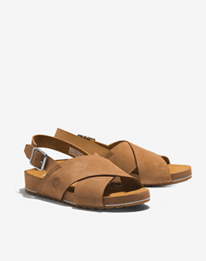Braune Sandalen mit überkreuzten Riemen und verstellbarem Fersenriemen, seitlich leicht versetzt auf hellem Hintergrund platziert