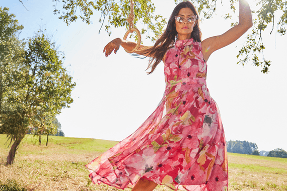 Robe midi sans manches à imprimé floral rose, personne debout en plein air dans un champ verdoyant