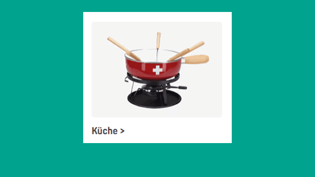Küche – roter Fonduetopf mit weissem Kreuz und mehreren Fonduespiessen auf schwarzem Rechaud