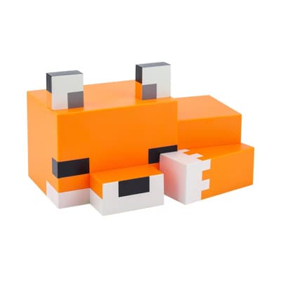 Orange-weiße, würfelförmige Spielfigur in Fuchsform liegt mit angezogenen Beinen auf der Seite