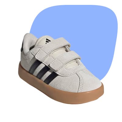 Kinder-Sneaker in Hellgrau mit zwei Klettverschlüssen, dunklen Seitenstreifen und heller Sohle vor blauem Hintergrund
