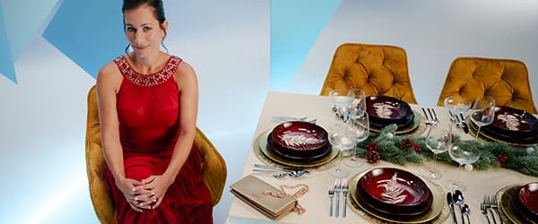 Frau in weißem Pullover hält geöffneten Geschenkkarton und Parfümflasche, umgeben von bunt verpackten Geschenken